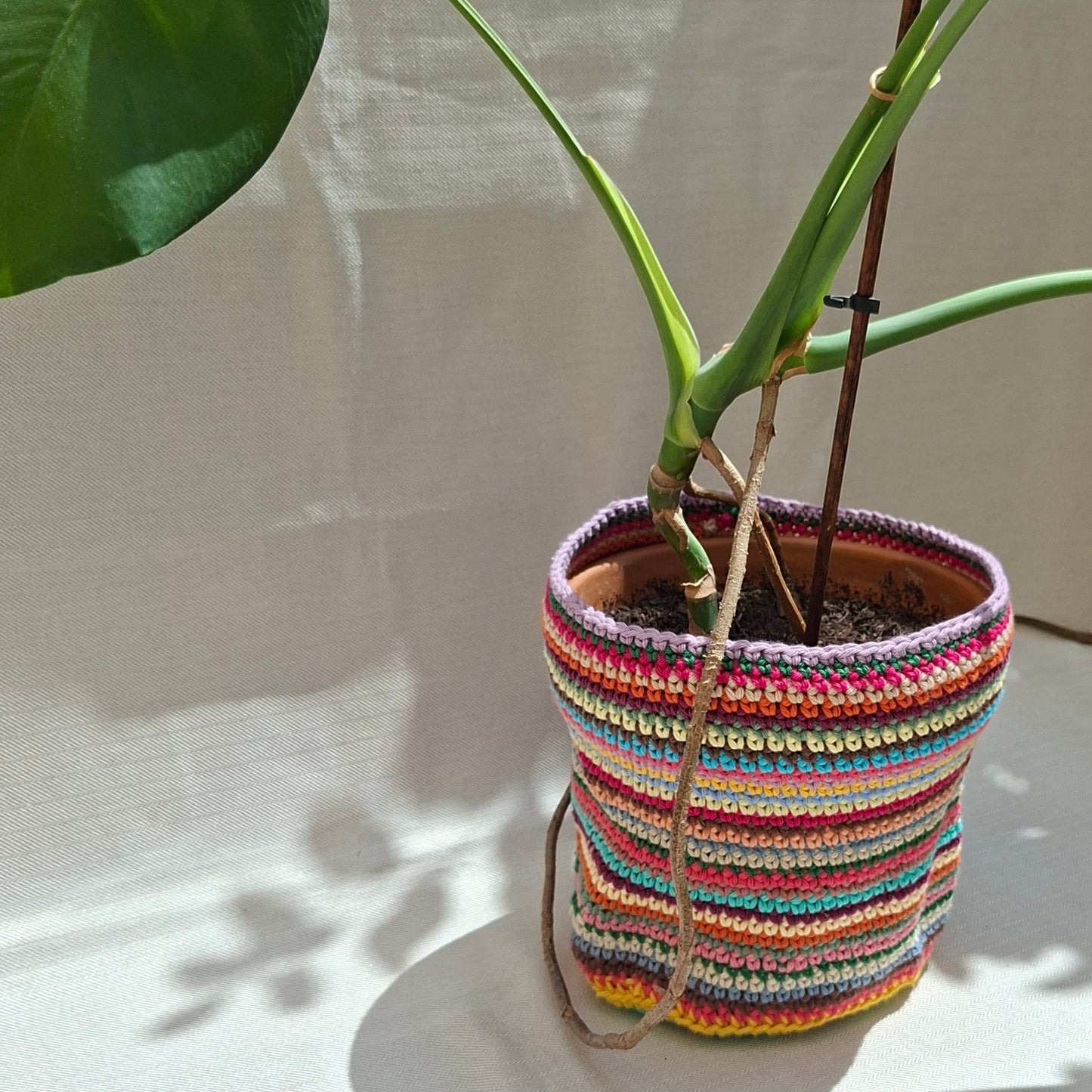 Multicoloured striped crochet plant pot cover