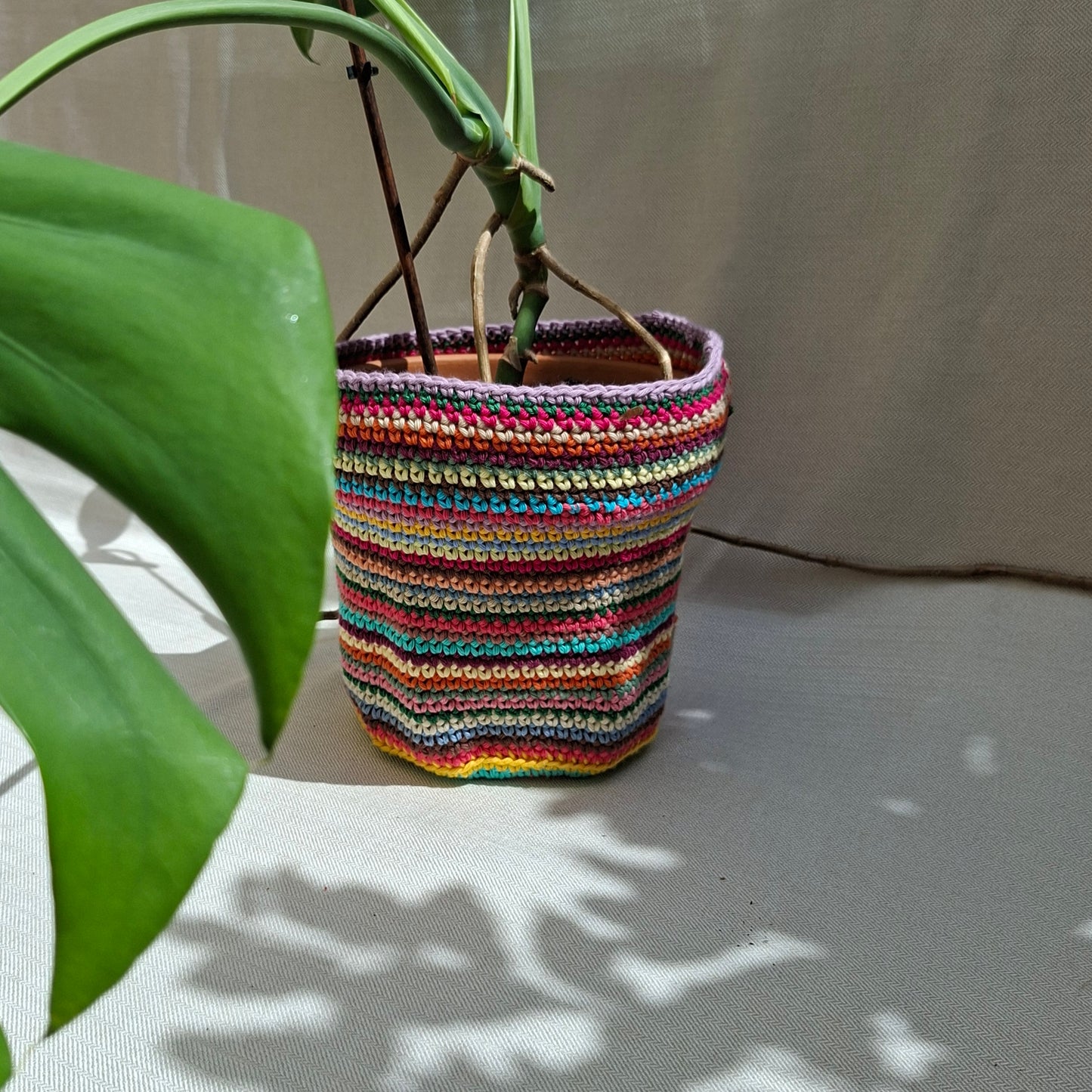 Multicoloured striped crochet plant pot cover