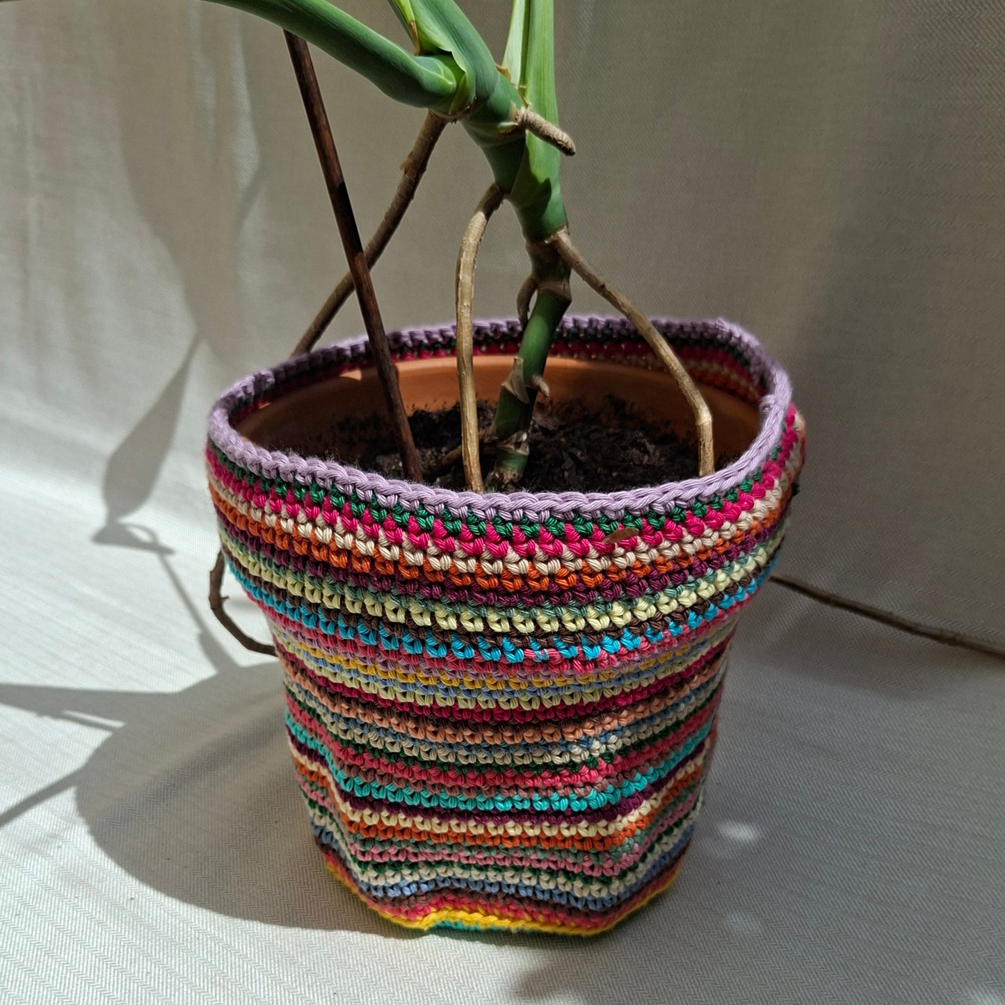 Multicoloured striped crochet plant pot cover