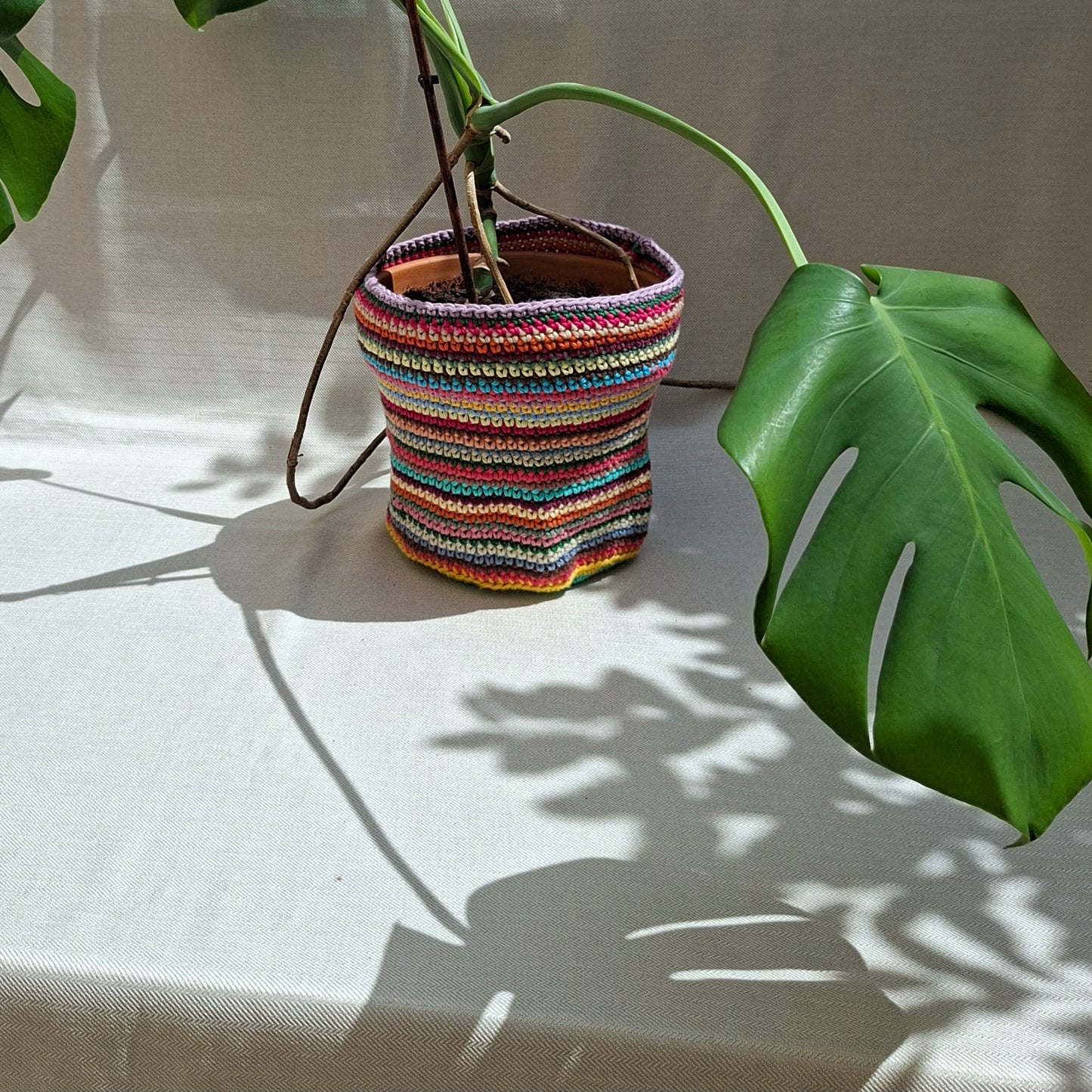 Multicoloured striped crochet plant pot cover